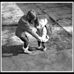 Two children and a muddy puddle