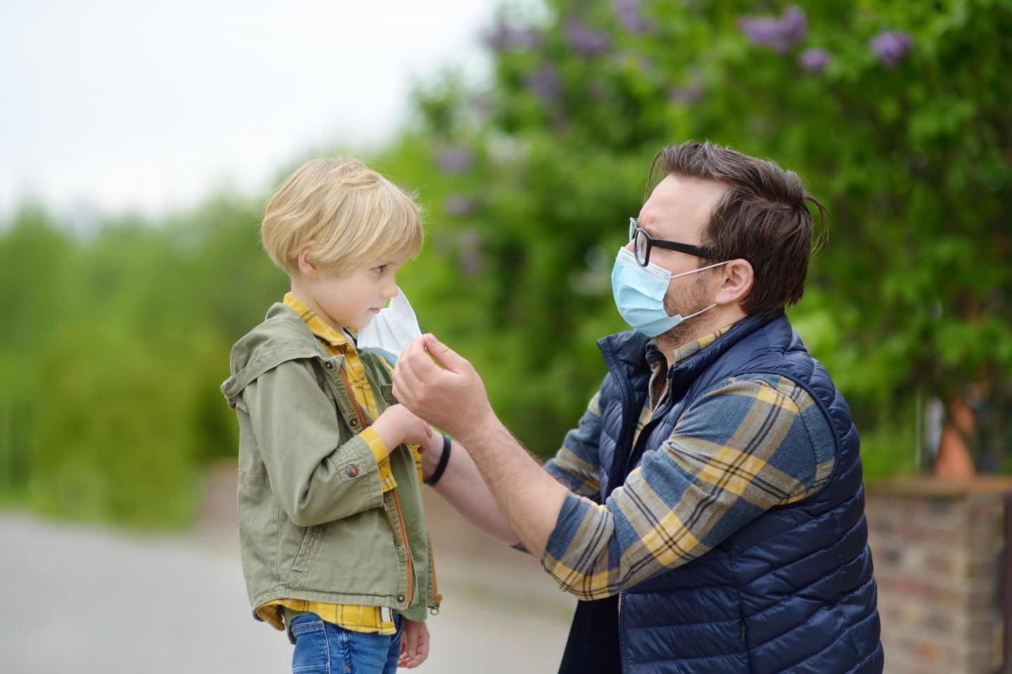 The COVID-19 generation are not snowflakes. Picture of man putting face mask on a child.