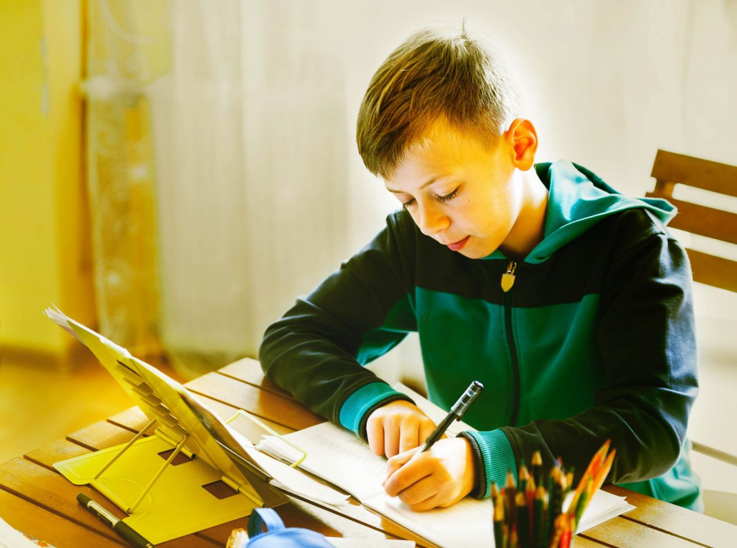 Schoolboy wearing sportswear in classroom instead of traditional school uniform.