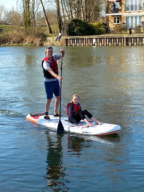 Man and child using SUP on a river