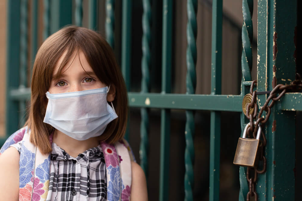 academic year comes to an end. Girl in face mask at school gates